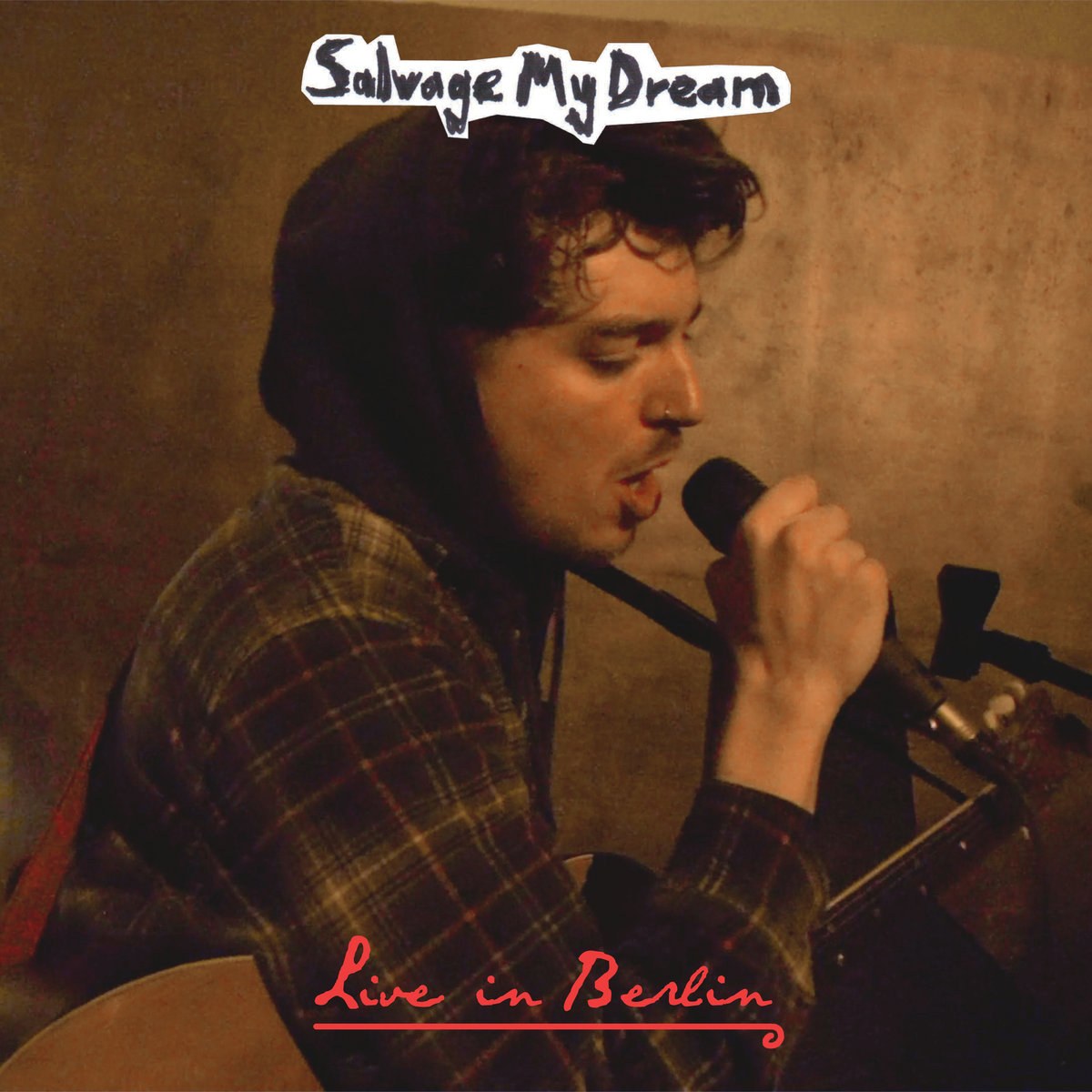 Live In Berlin cover showing Robin Fisher singing into a microphone with a guitar.