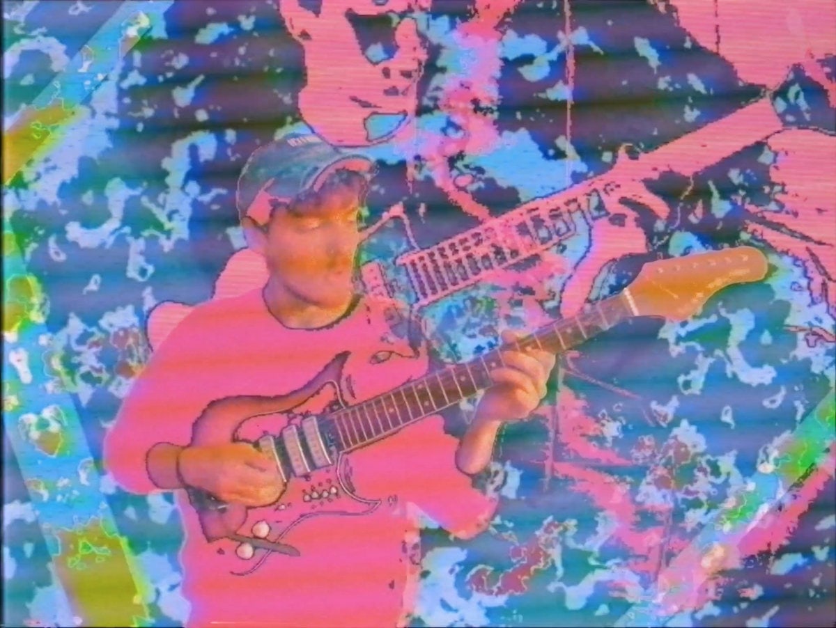 A saturated video-feedback collage of Robin Fisher playing electric guitar in vivid pink and blue.